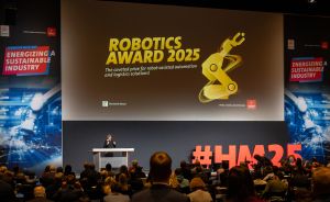 Vortragender auf Bühne vor Leinwand mit „Robotics Award 2025"-Präsentation, Publikum im Vordergrund, Hashtag #HM25 sichtbar.