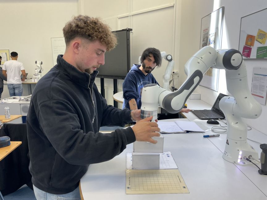 Schüler arbeitet mit Roboterarm